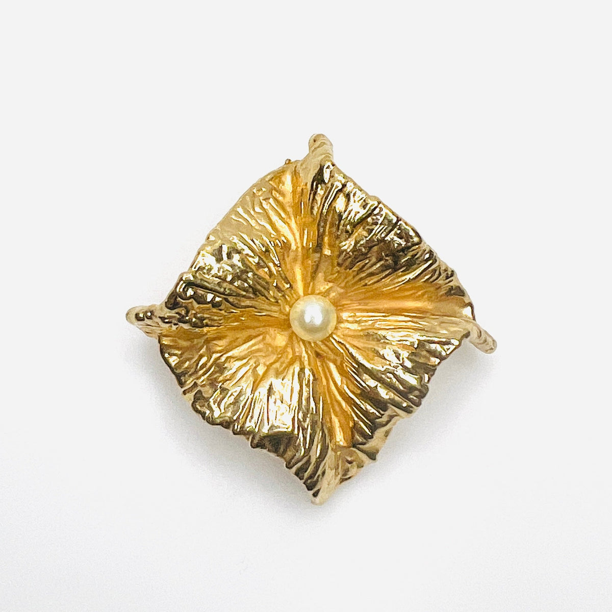 Vintage 1980s Napier gold-tone sculptural brooch with crumpled foil-inspired textured design and central ivory faux pearl.
