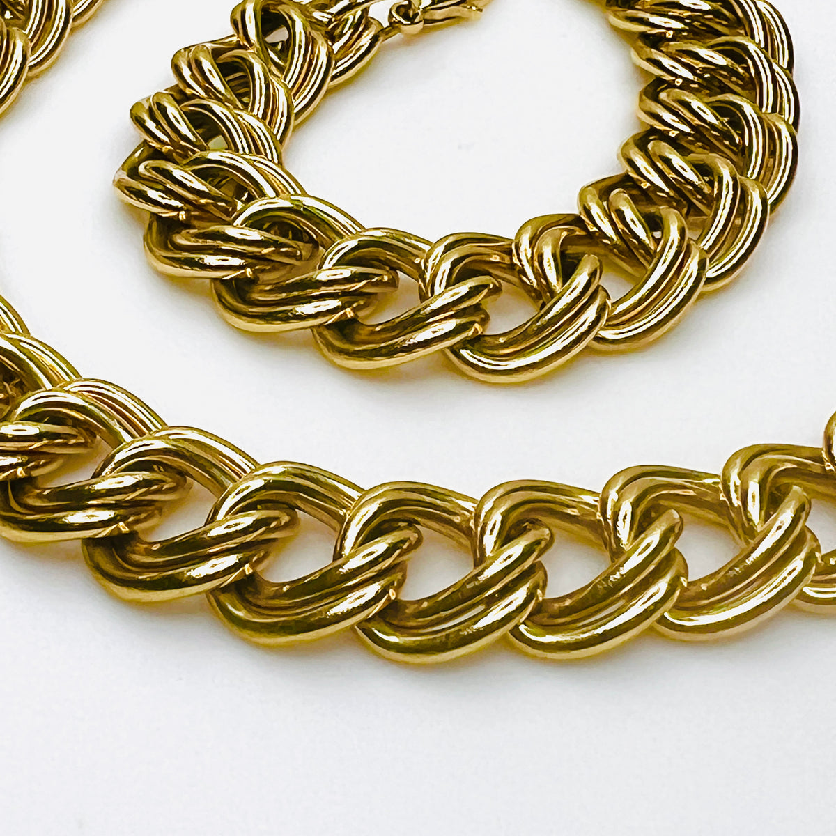 Close-up of vintage chunky gold-tone necklace showing polished, dimensional double links and substantial chain construction.