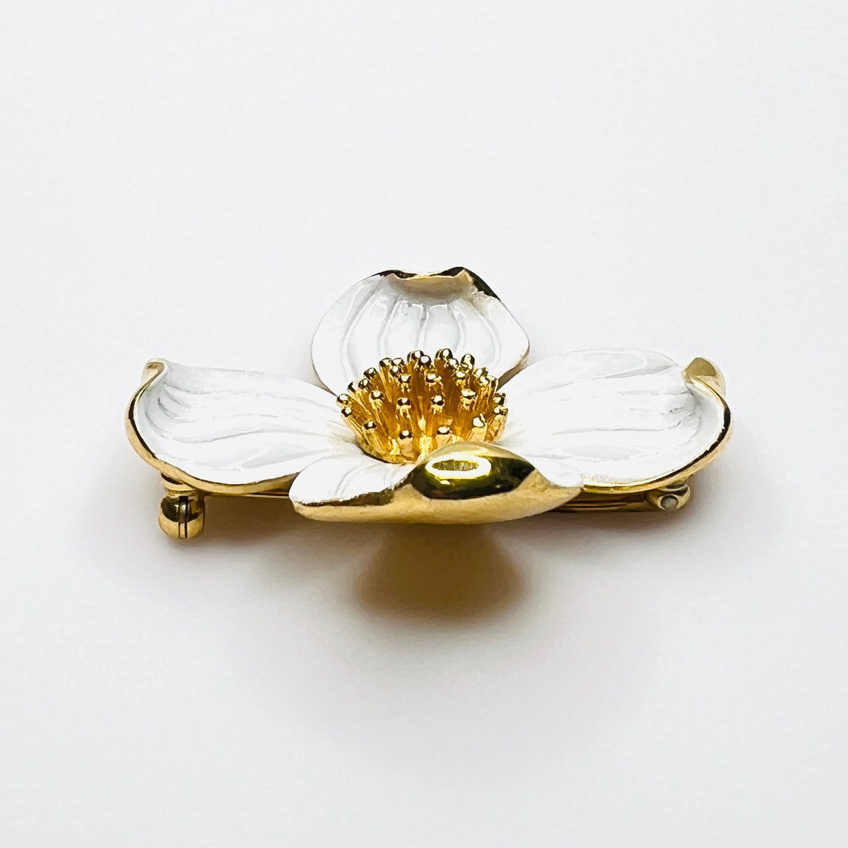 Side profile of vintage Trifari white enamel dogwood brooch showing dimensional petals.