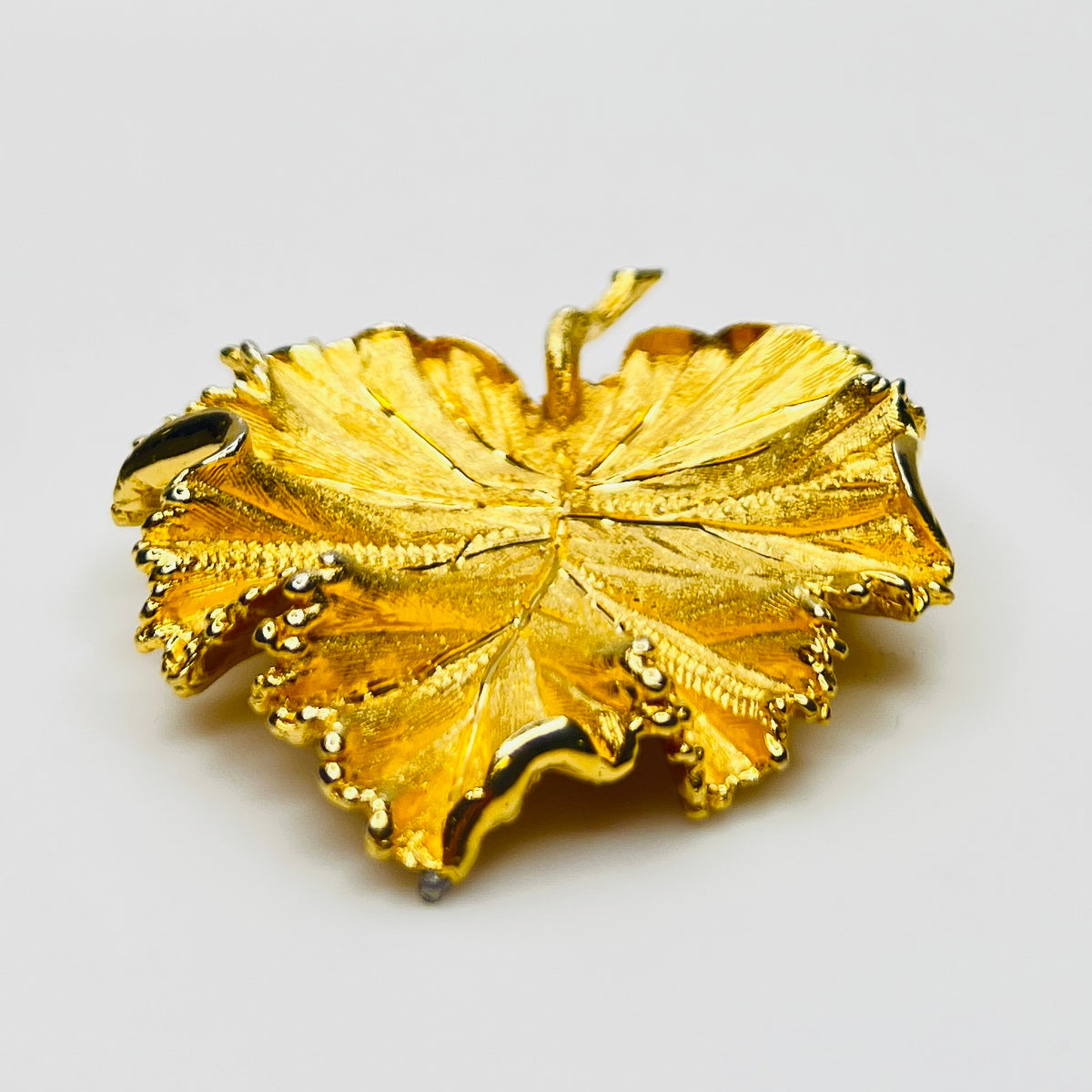 Side profile of textured gold leaf brooch