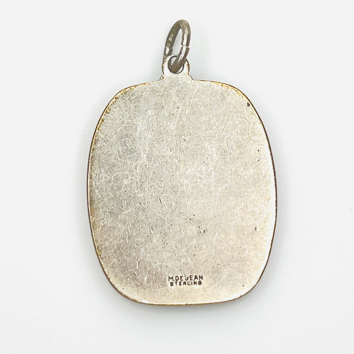 Reverse of signed M. De Jean Sterling St. Christopher pendant with maker's mark.