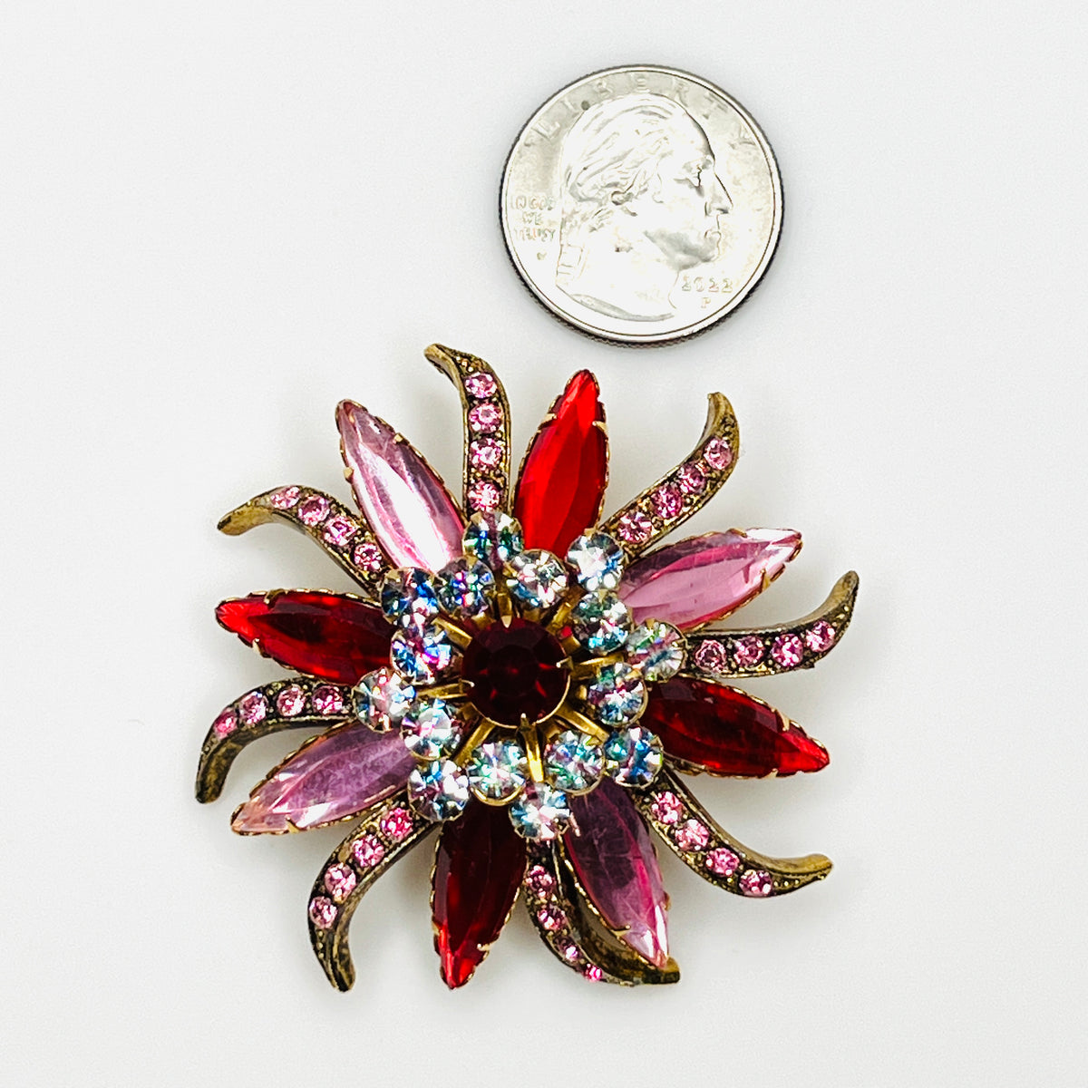 Oversized 1950s Selini rhinestone flower brooch beside a quarter showing its colorful 2 1/4-inch starburst design.