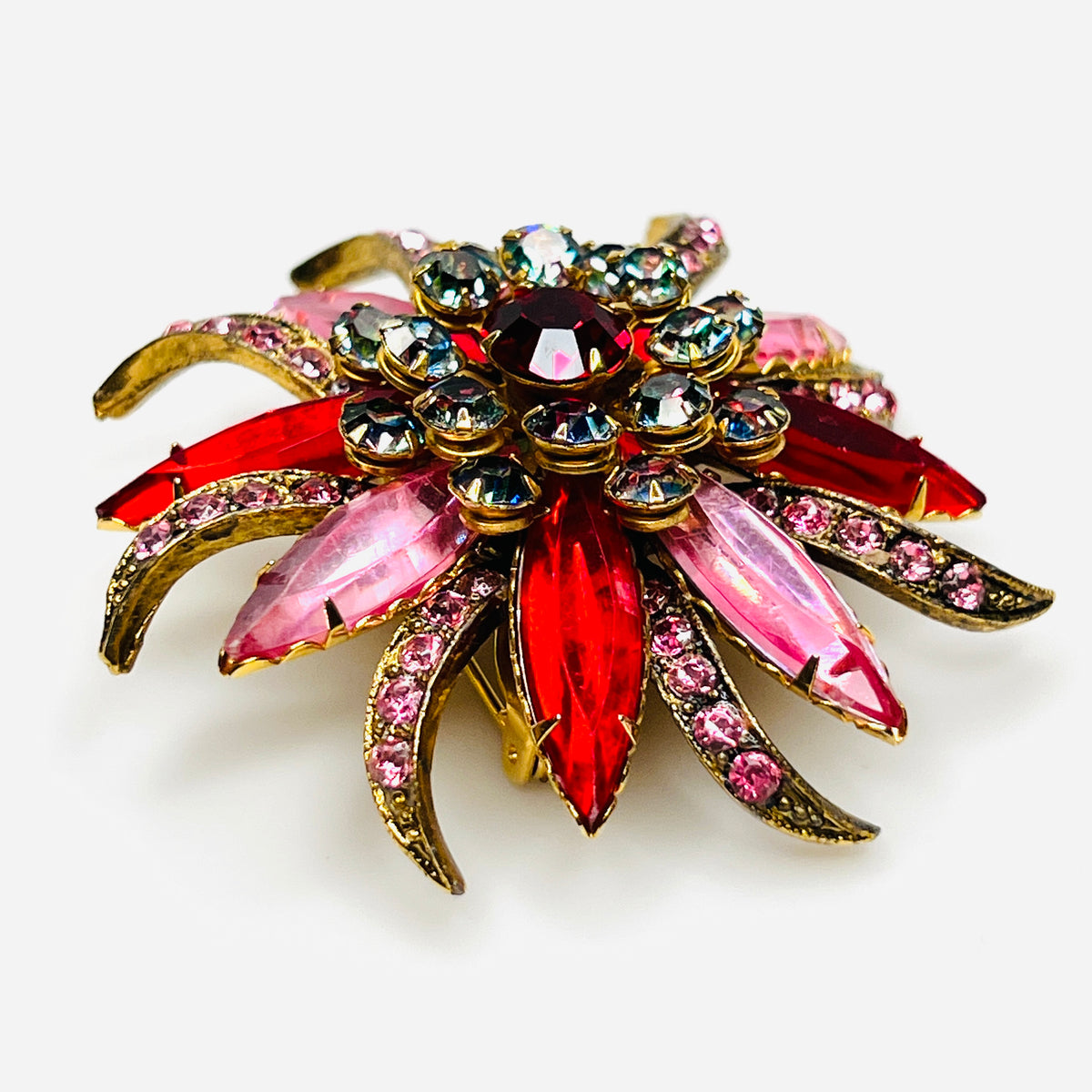 Side view of vintage Selro Selini floral brooch showing layered red, pink, and iridescent prong-set rhinestones.