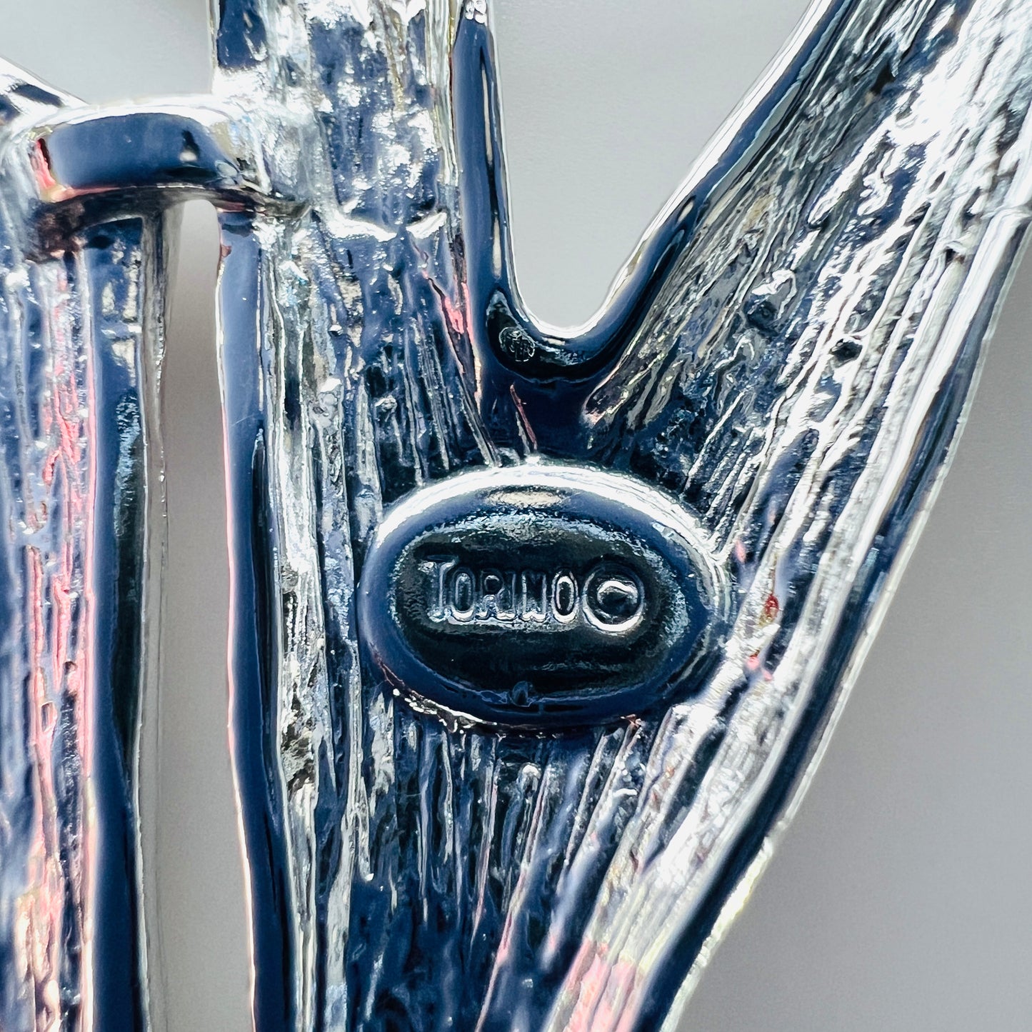 Close-up of Torino signature and copyright mark on vintage abstract brooch.
