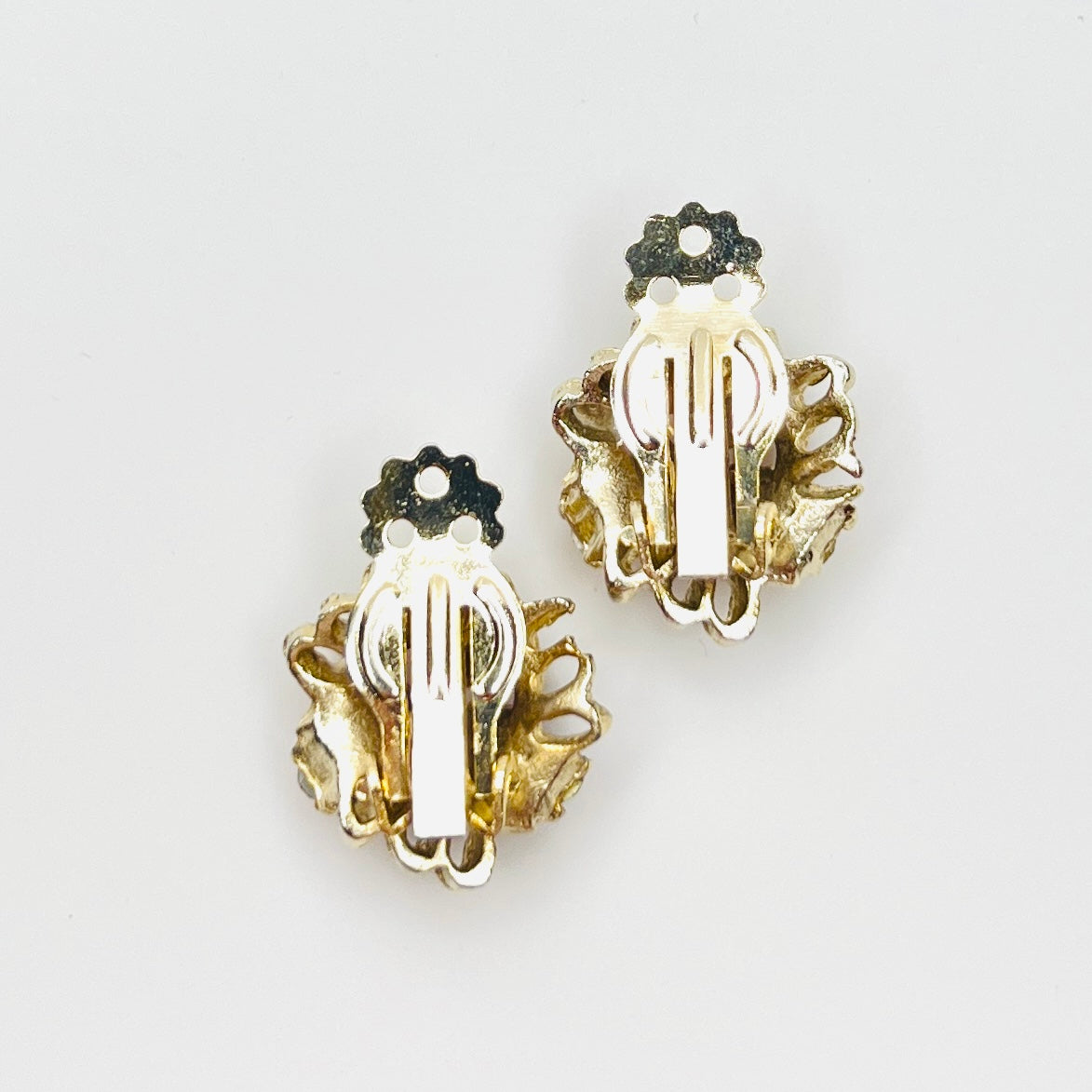 Back of vintage 1950s gold-tone clip-on earrings with secure clips.