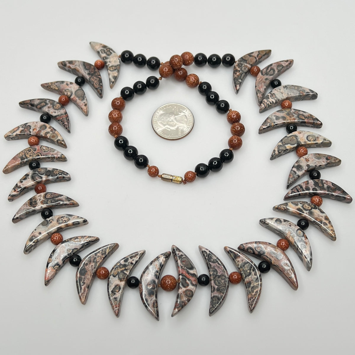 Close-up of asteroid jasper necklace with goldstone and obsidian beads