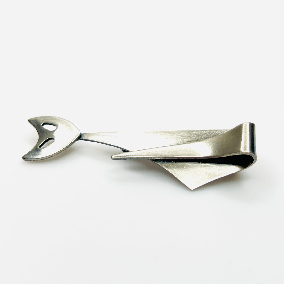 Side profile of vintage Modernist cat brooch showing layered sculptural stainless steel construction.