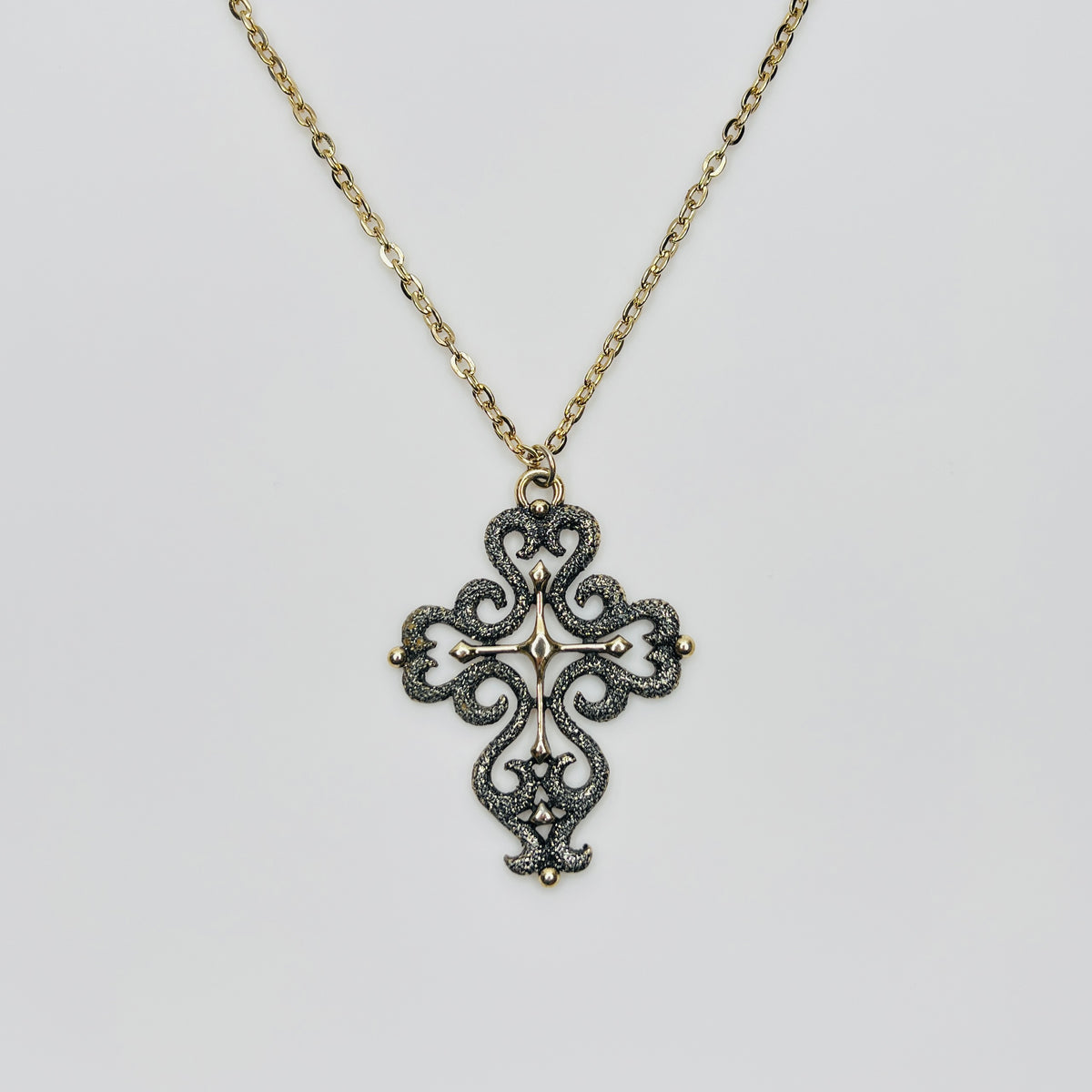Large gold tone cross pendant necklace with textured filigree design