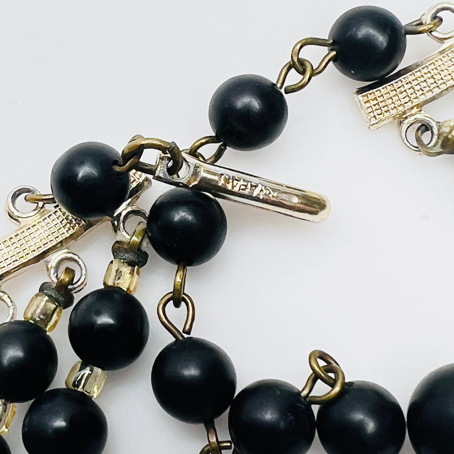Close view of Japan stamped clasp on vintage black bead necklace