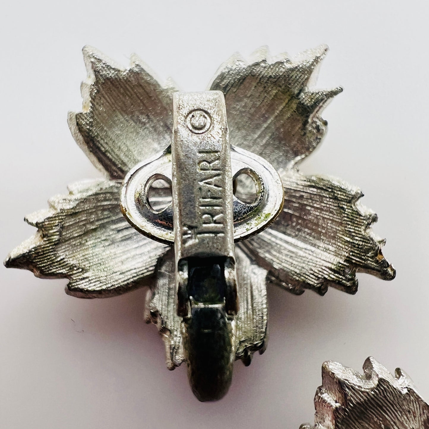Close up of Crown Trifari mark on vintage earring clip