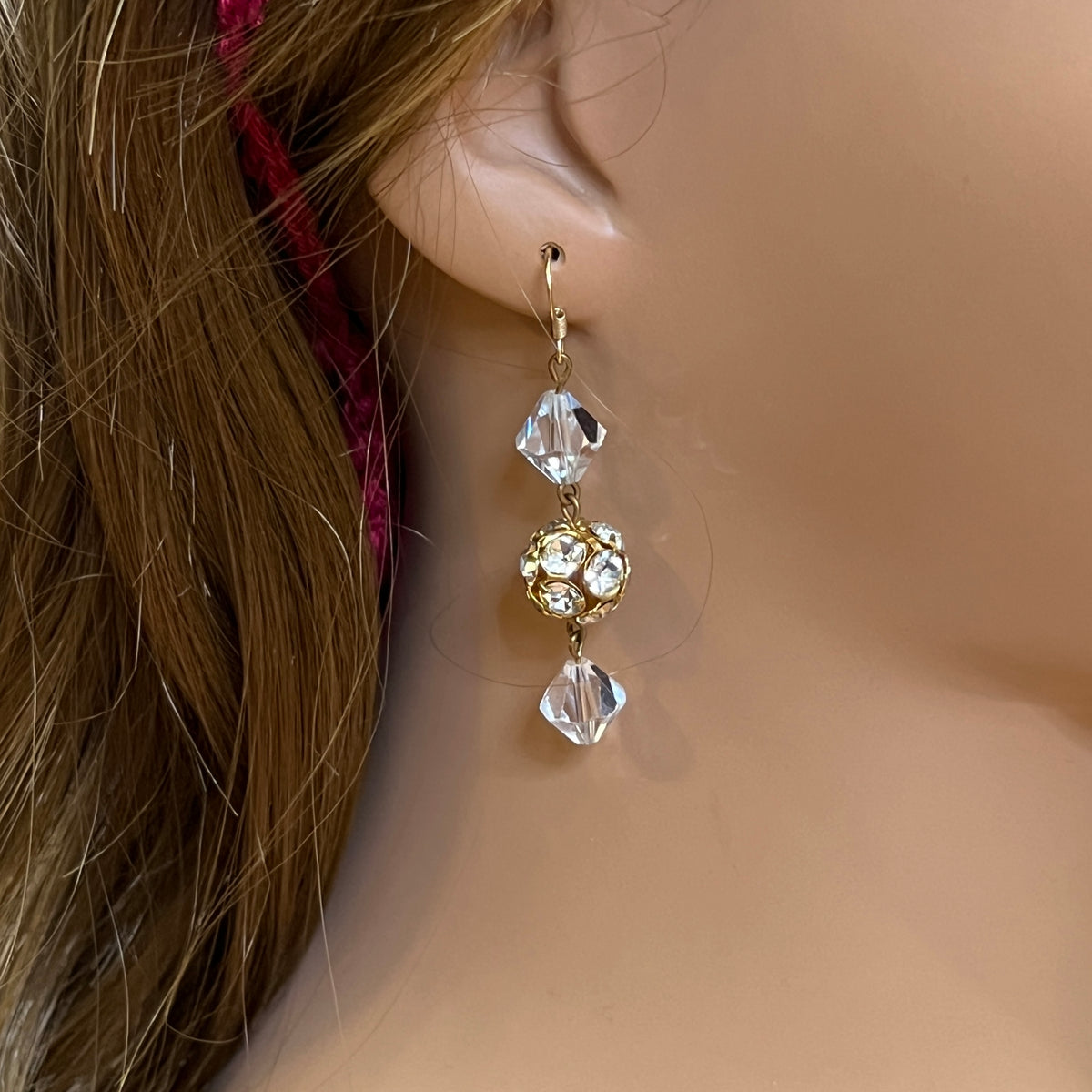 Close-up of clear vintage crystal drop earrings with sparkle detail