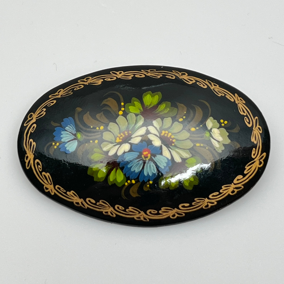 Russian black lacquer brooch with hand-painted floral design and gold border