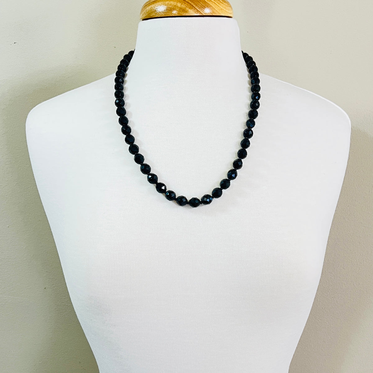 Vintage jet black faceted glass bead necklace worn on mannequin