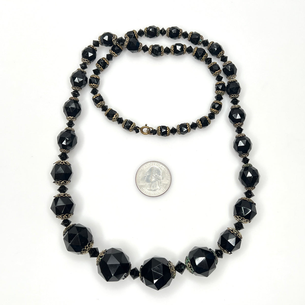 Vintage black glass necklace with graduated beads and brass-tone accents