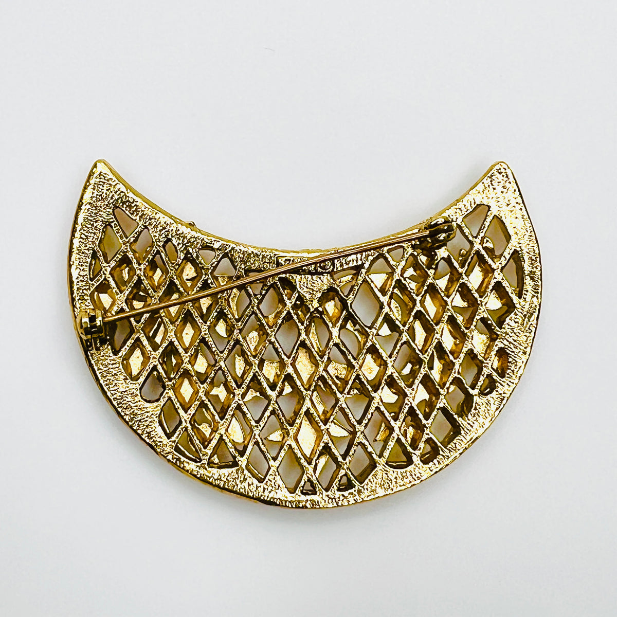 Reverse of vintage 1960s Lisner floral filigree brooch showing diamond-pattern openwork construction and rollover clasp.