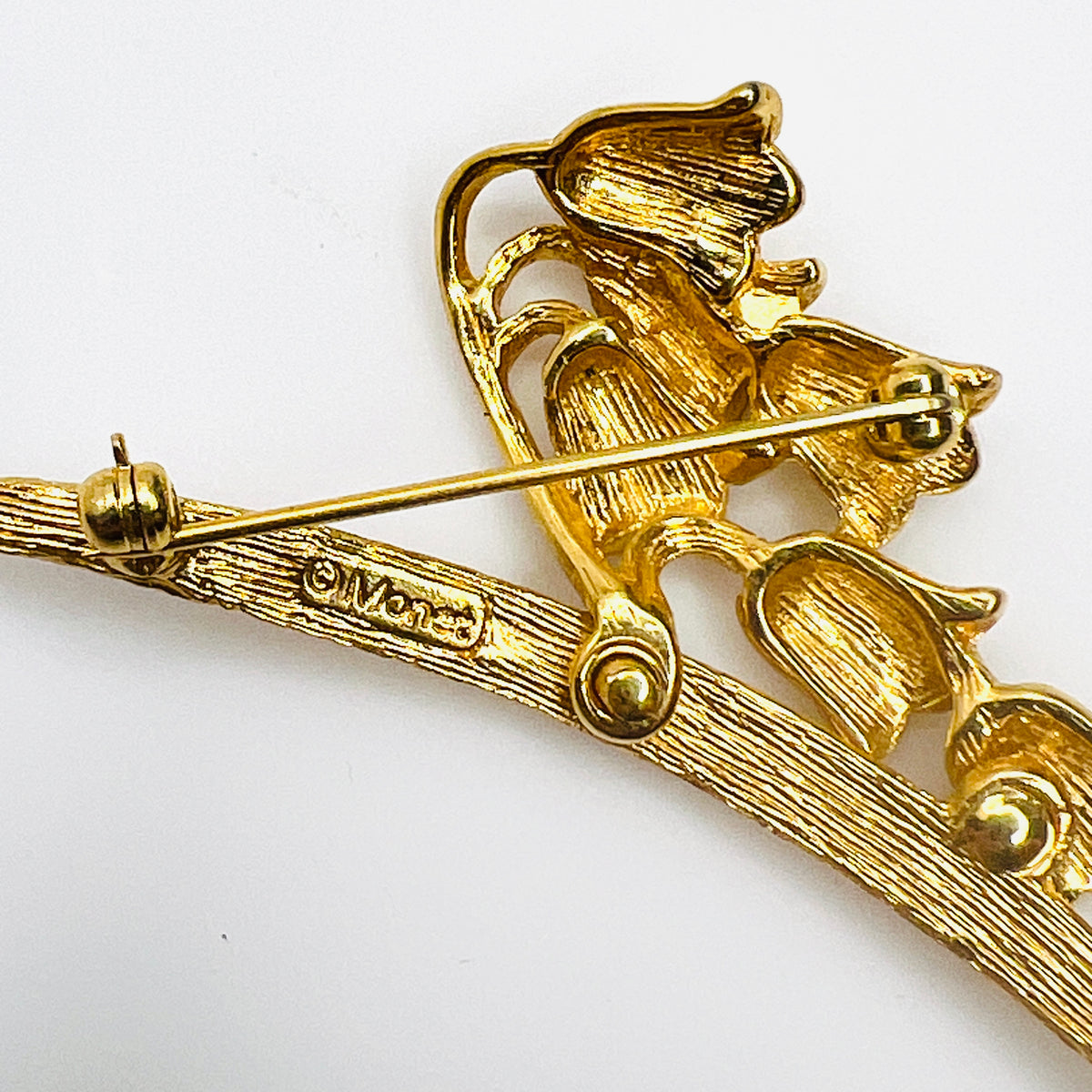 Reverse of 1960s Monet lily of the valley brooch showing gold-tone construction and rollover clasp