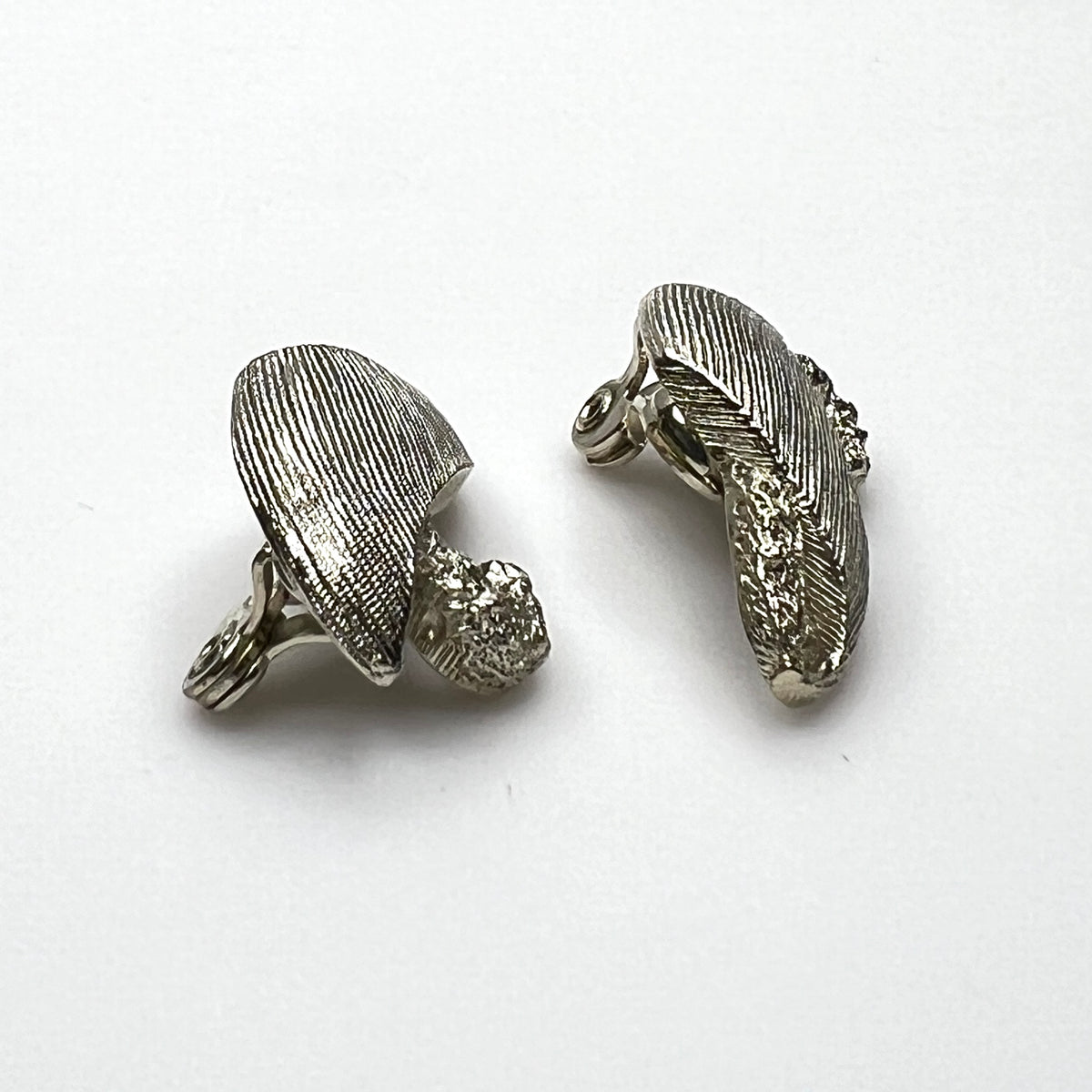 Side view of vintage Monet sculptural brushed gold tone clip-on earrings
