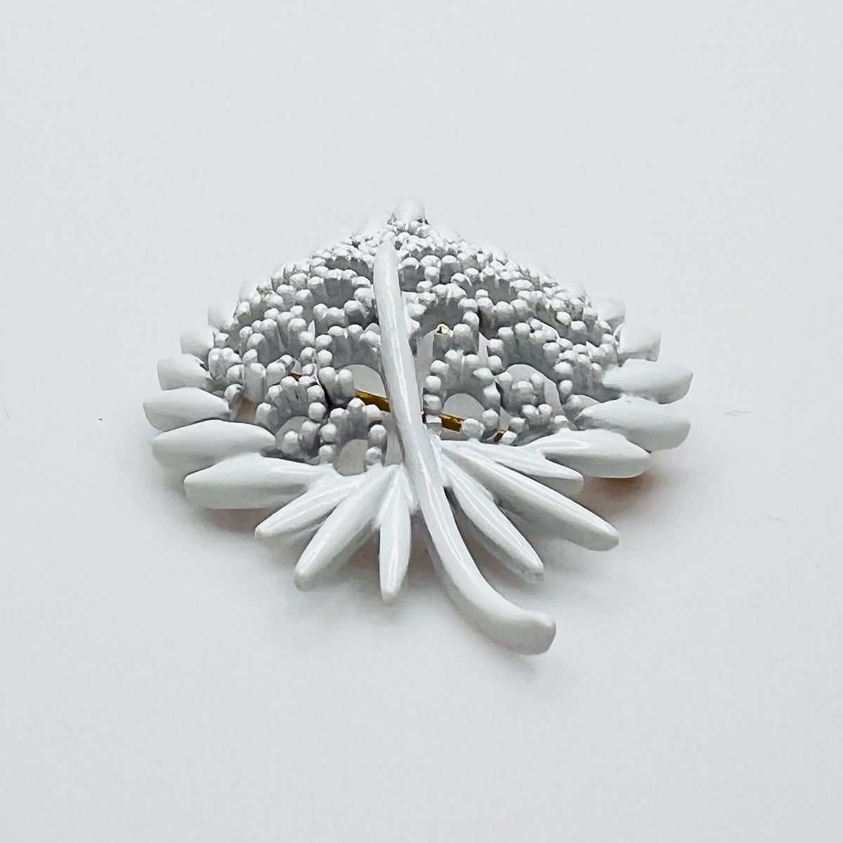 Side profile of vintage white enamel figural brooch