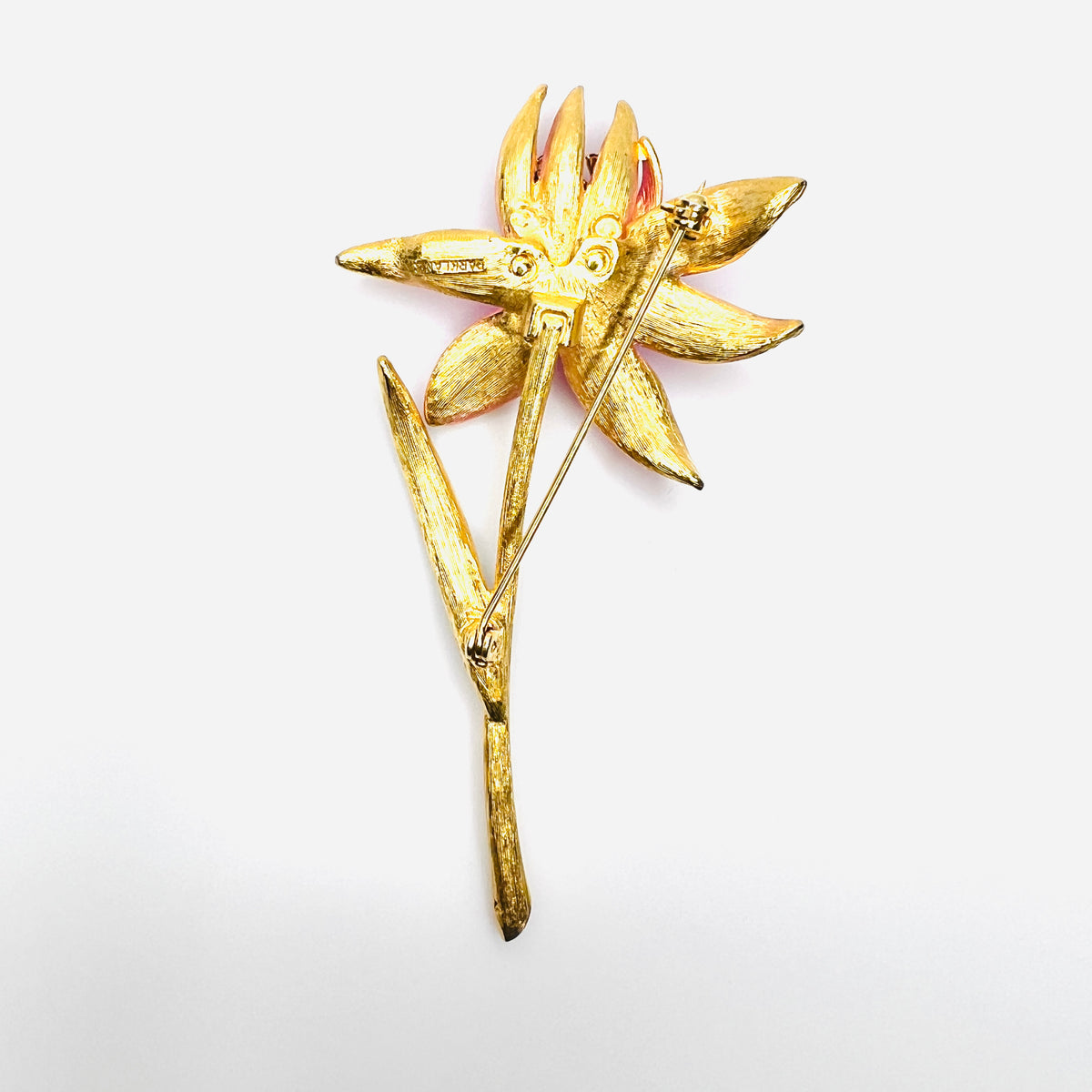 Reverse of vintage Park Lane pink enamel flower brooch showing pin clasp and gold tone finish