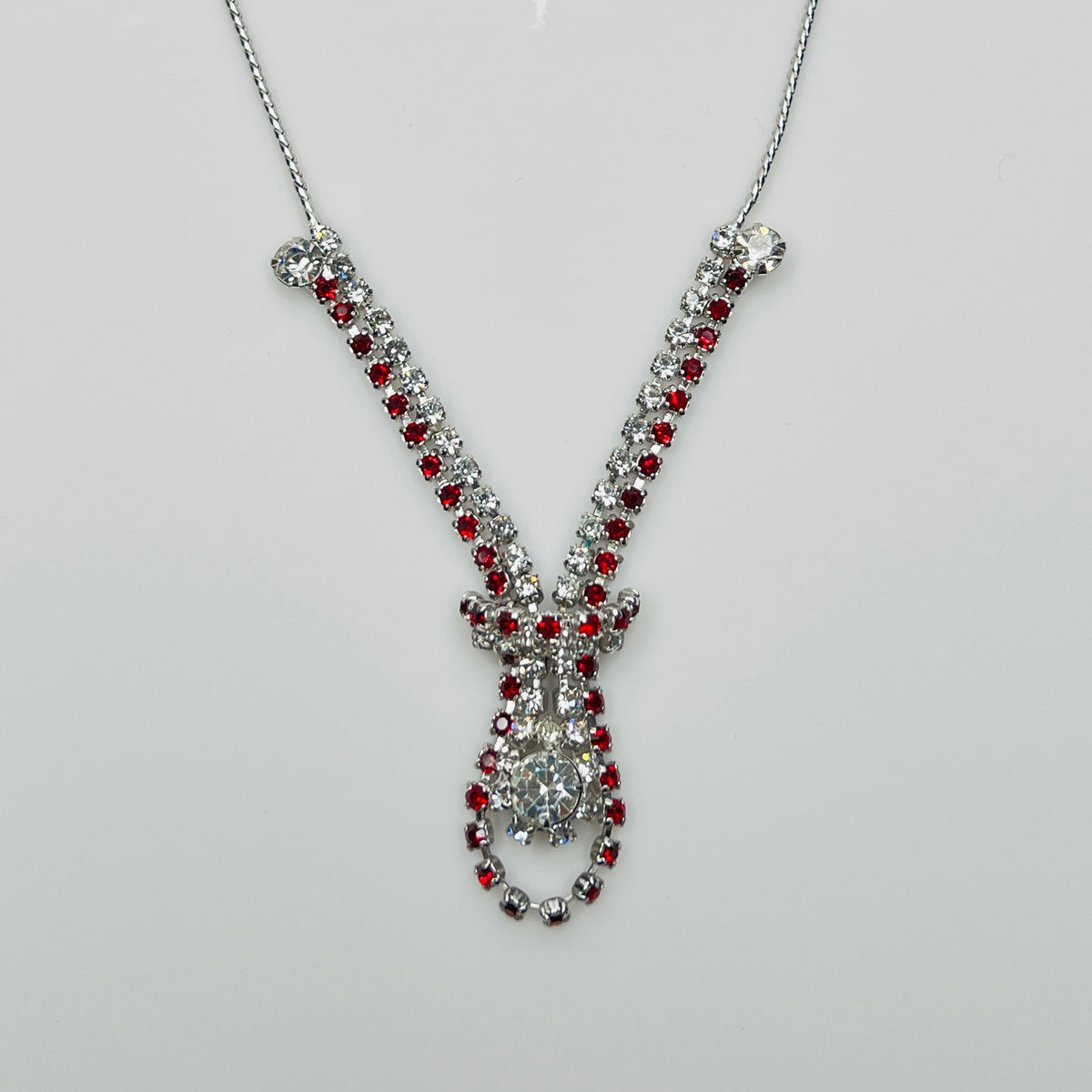 Close-up of 1950s V-shaped red rhinestone drop necklace