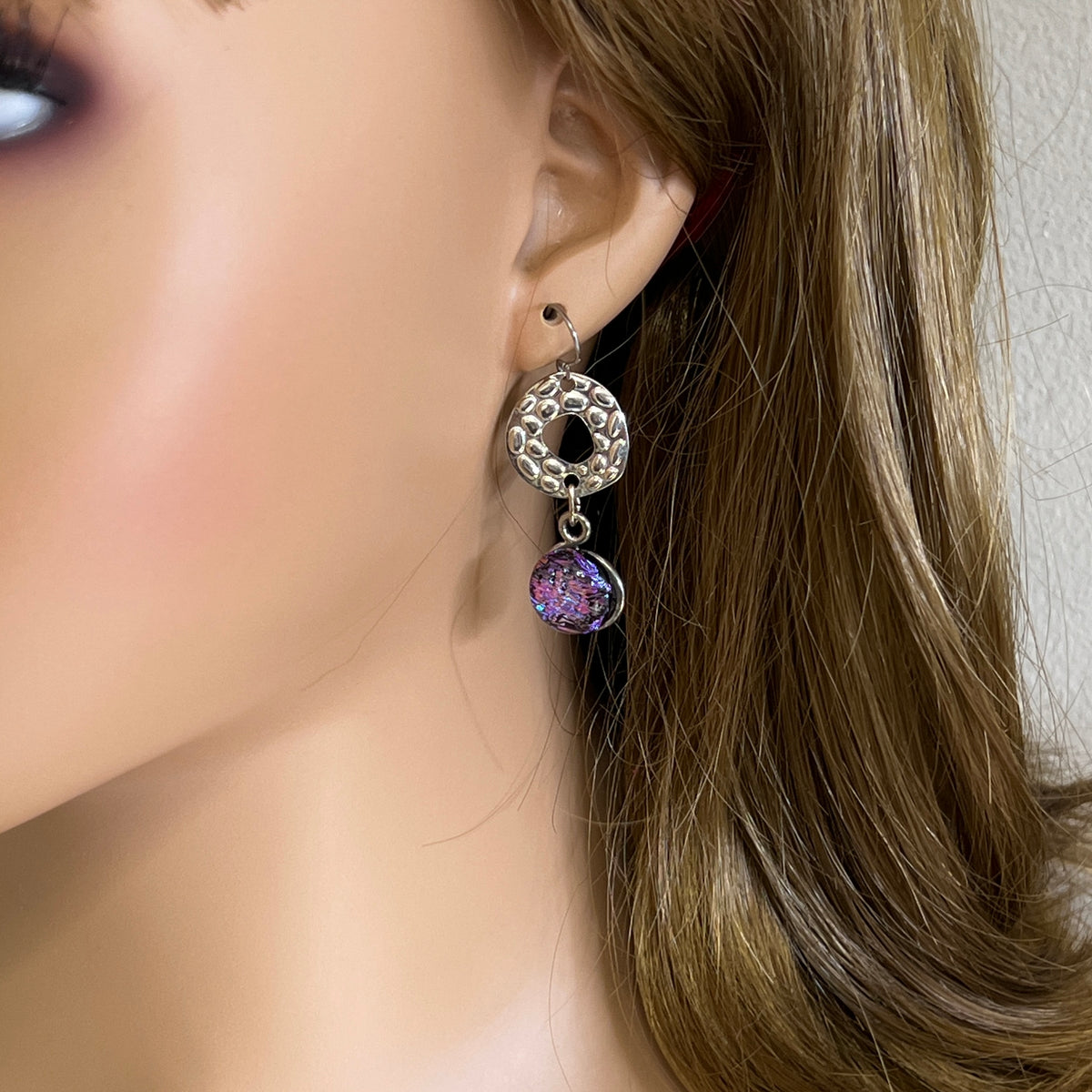 Artisan dangle earrings worn on ear