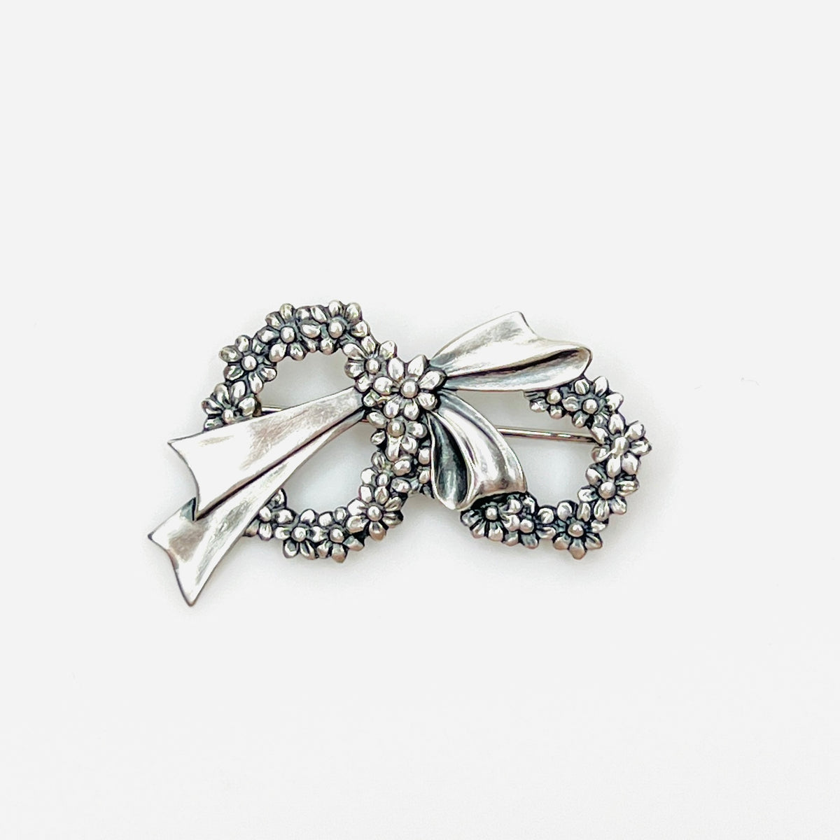 Vintage sterling silver floral wreath bow brooch with detailed daisy flowers, circa 1960s.