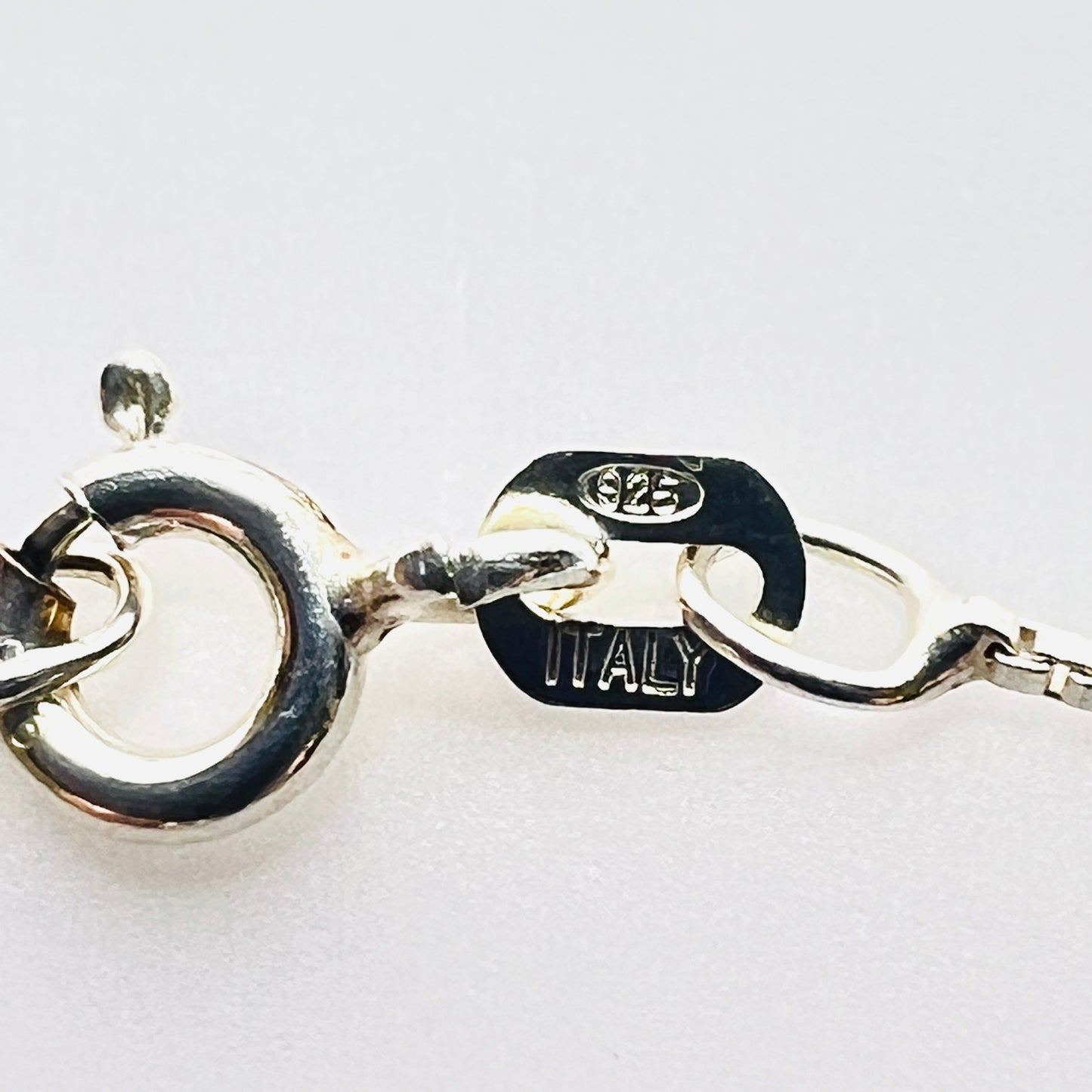 Close-up of spring ring clasp stamped 925 Italy on sterling silver box chain.