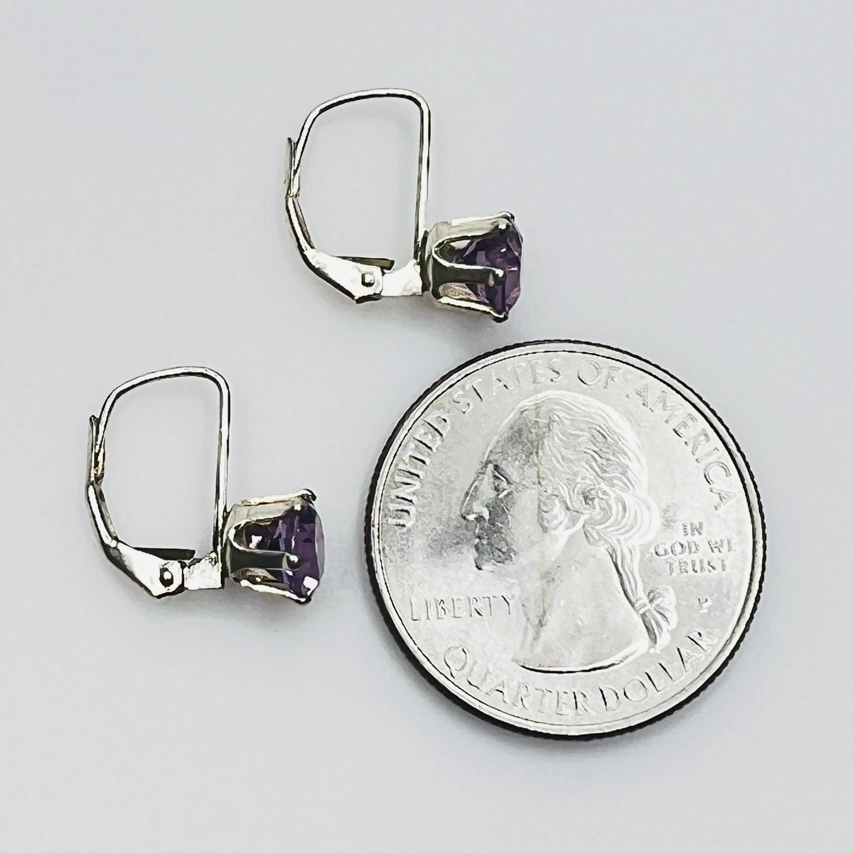 Vintage purple topaz earrings next to coin for size reference