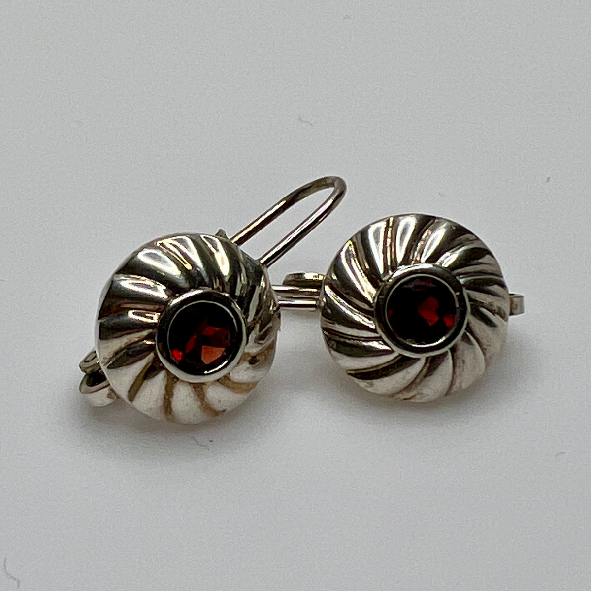 Sterling silver leverback earrings with red spinel cabochons in swirl design