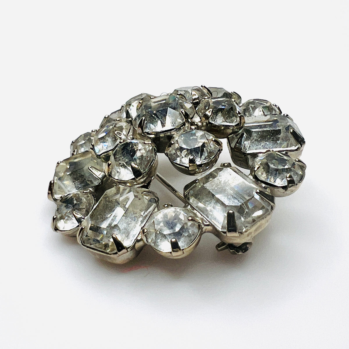 Side view of vintage Weiss rhinestone brooch showing raised silver-tone settings and dimensional crystal cluster construction.