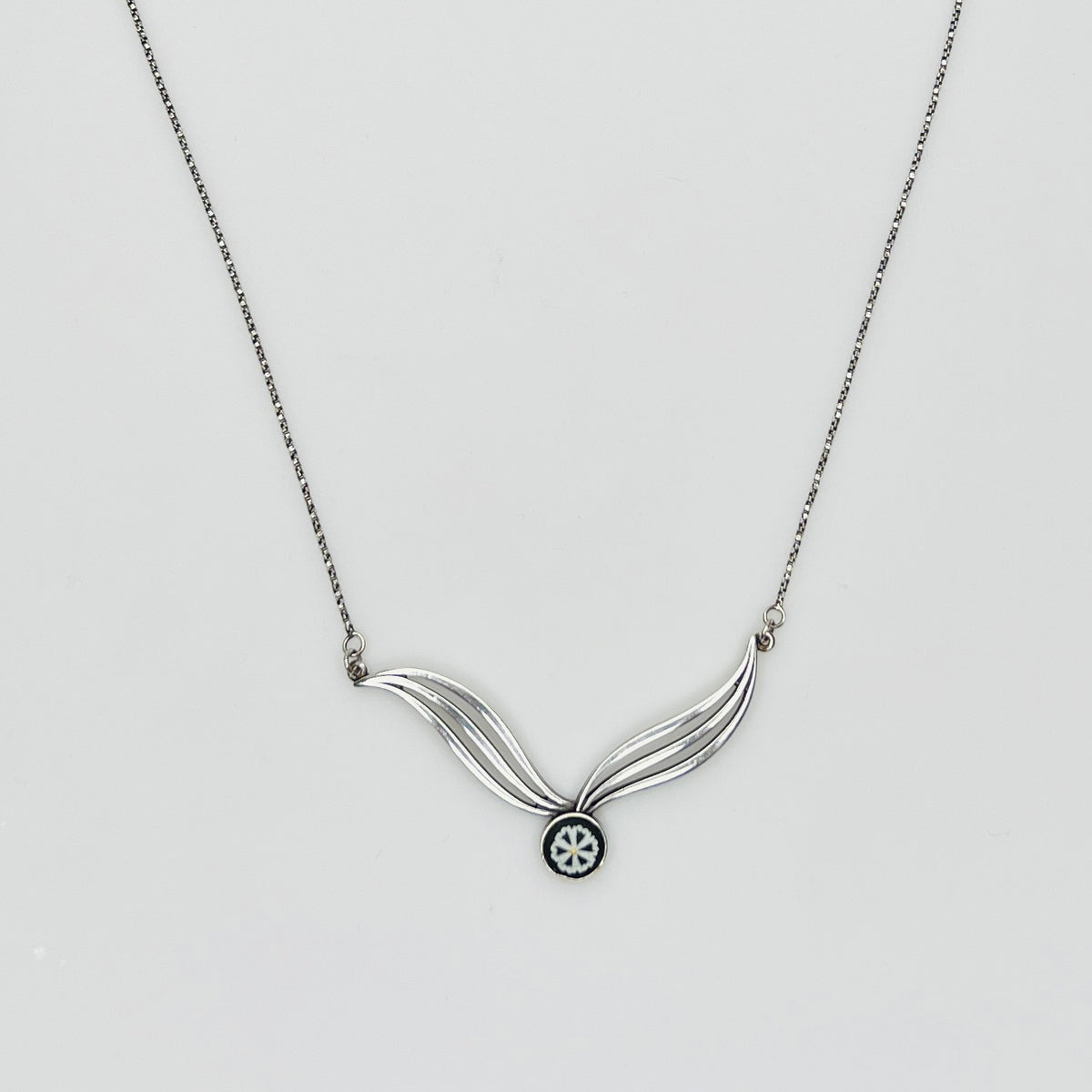 Flat lay of silver Wedgwood pendant necklace with chain