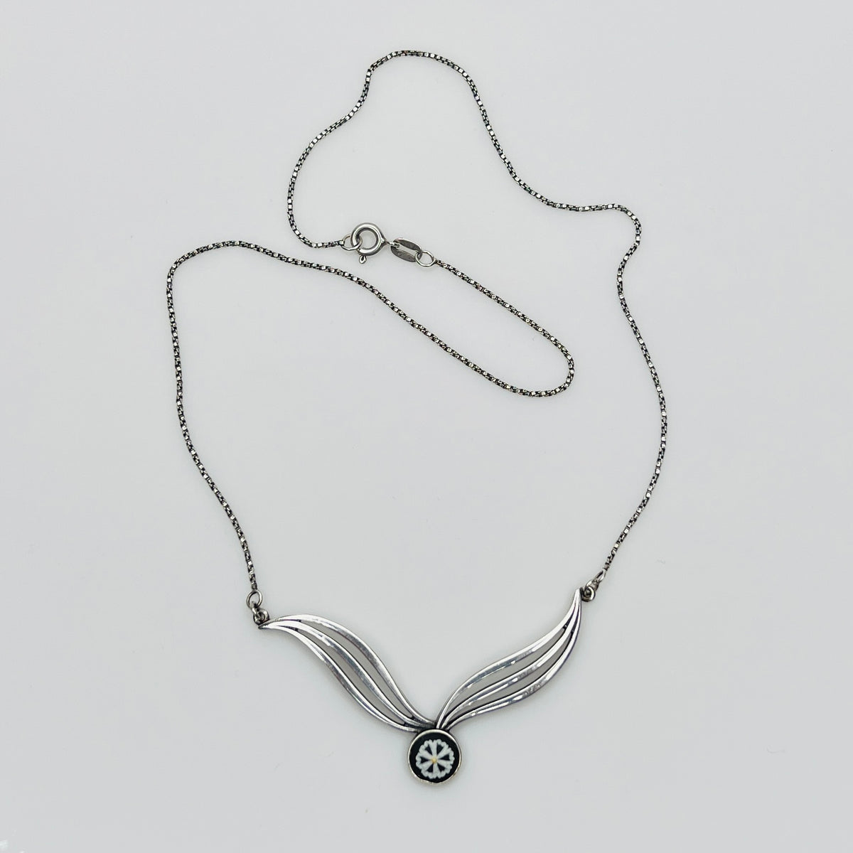 Flat lay of silver Wedgwood pendant necklace with chain