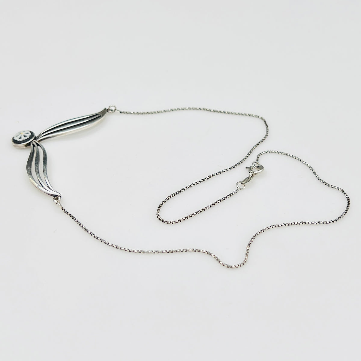 Flat lay of silver Wedgwood pendant necklace with chain