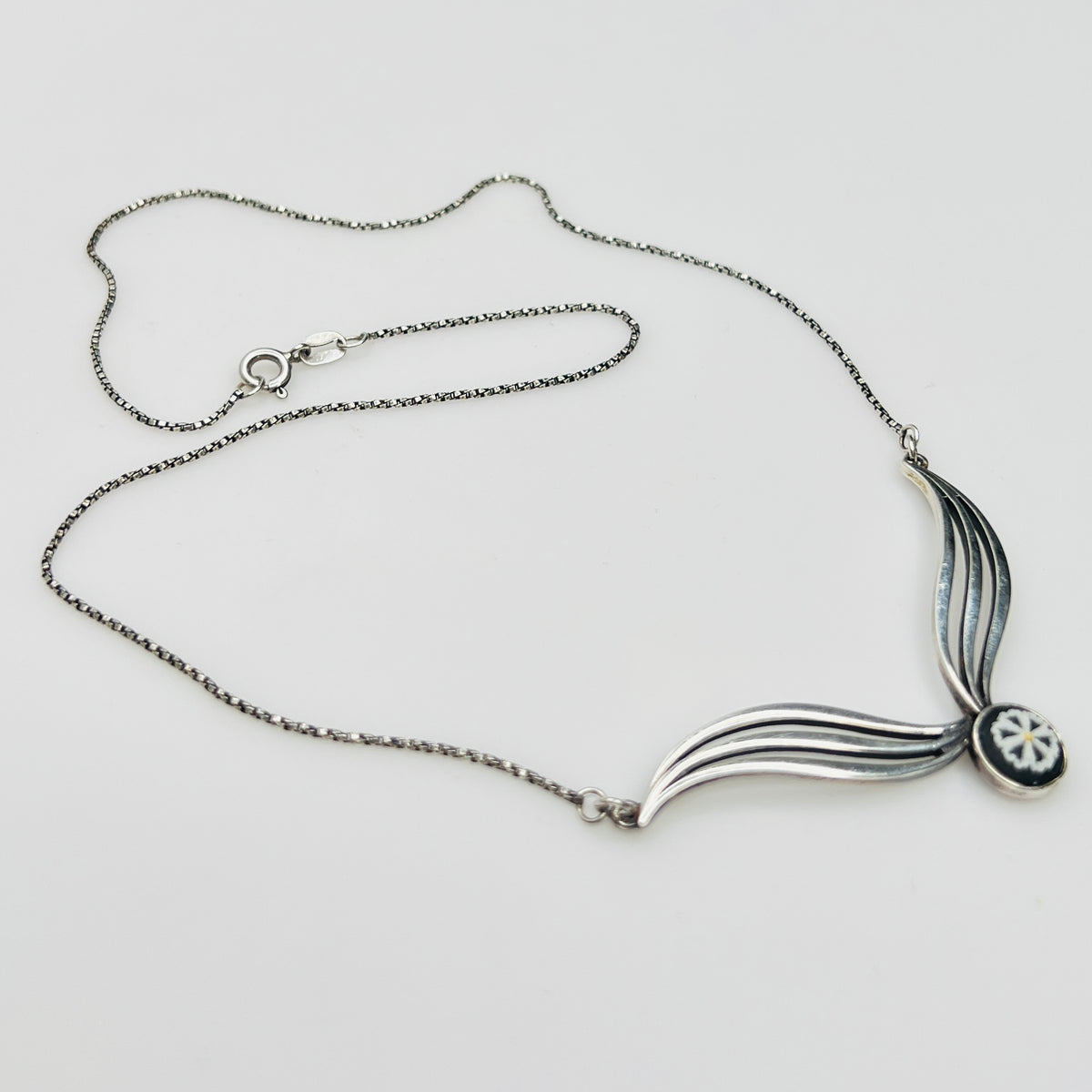 Flat lay of silver Wedgwood pendant necklace with chain