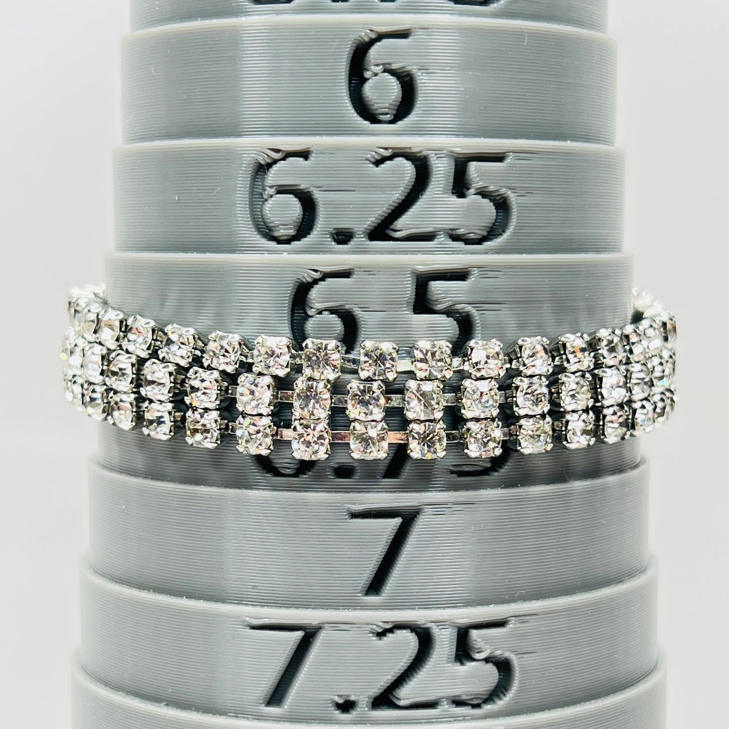 Signed Weiss triple strand clear crystal rhinestone bracelet in silver tone metal on bracelet mandrel