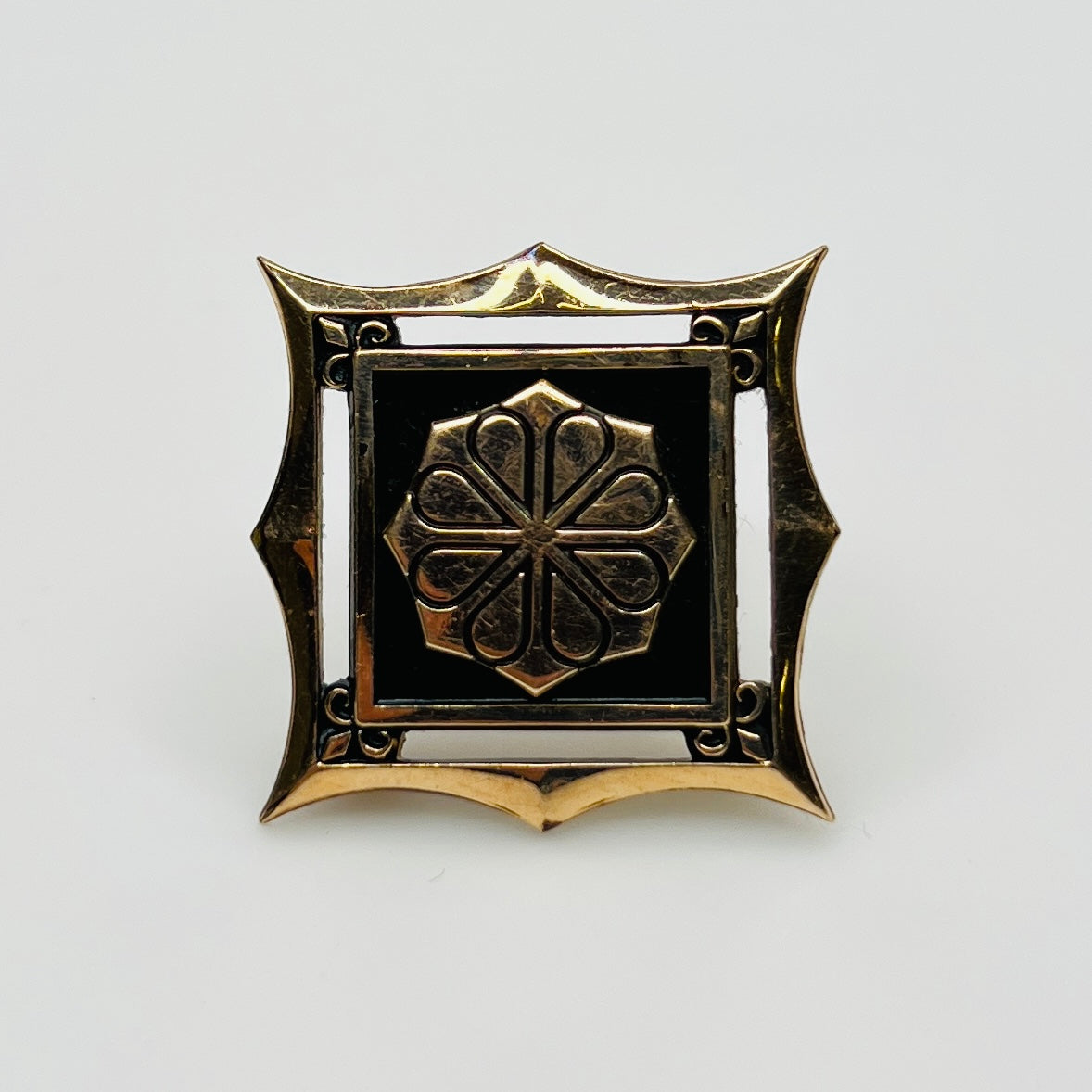 Midcentury black enamel and gold-tone service award brooch with geometric emblem