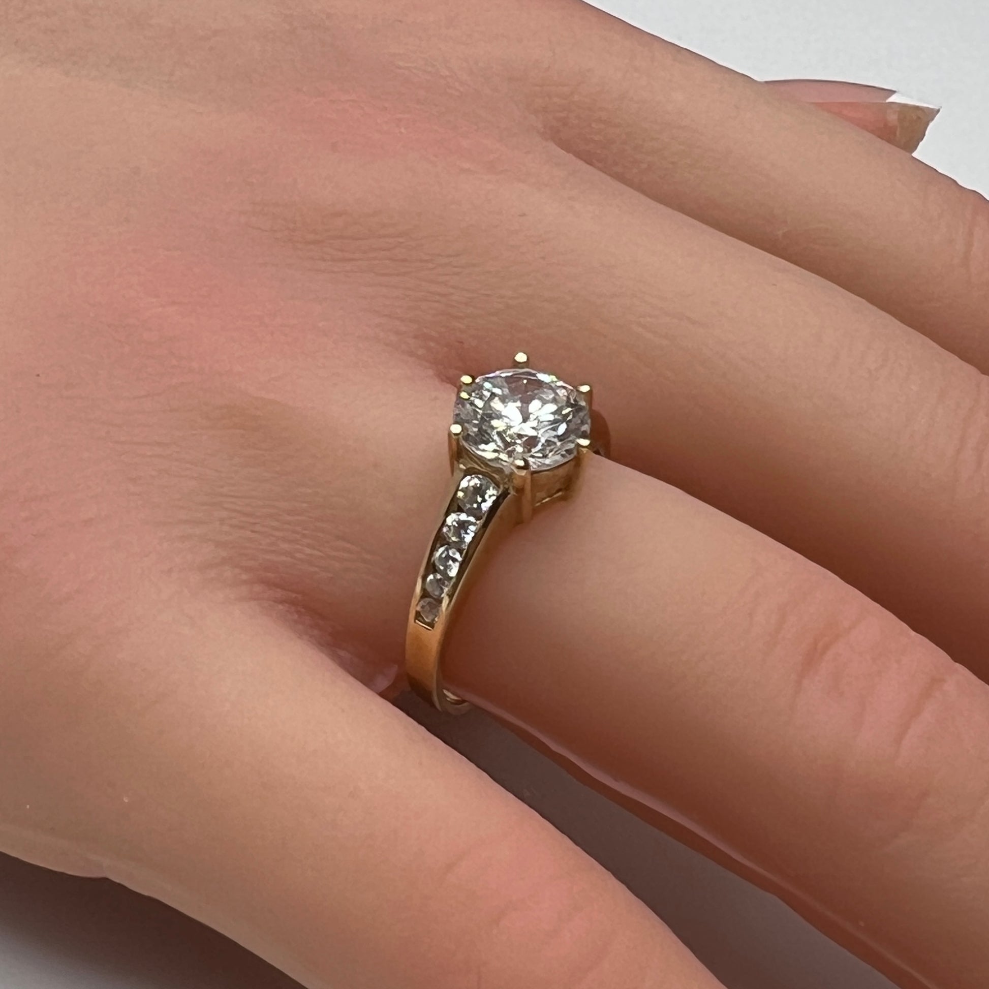 Vintage 10K gold CZ solitaire ring on hand with channel-set accents