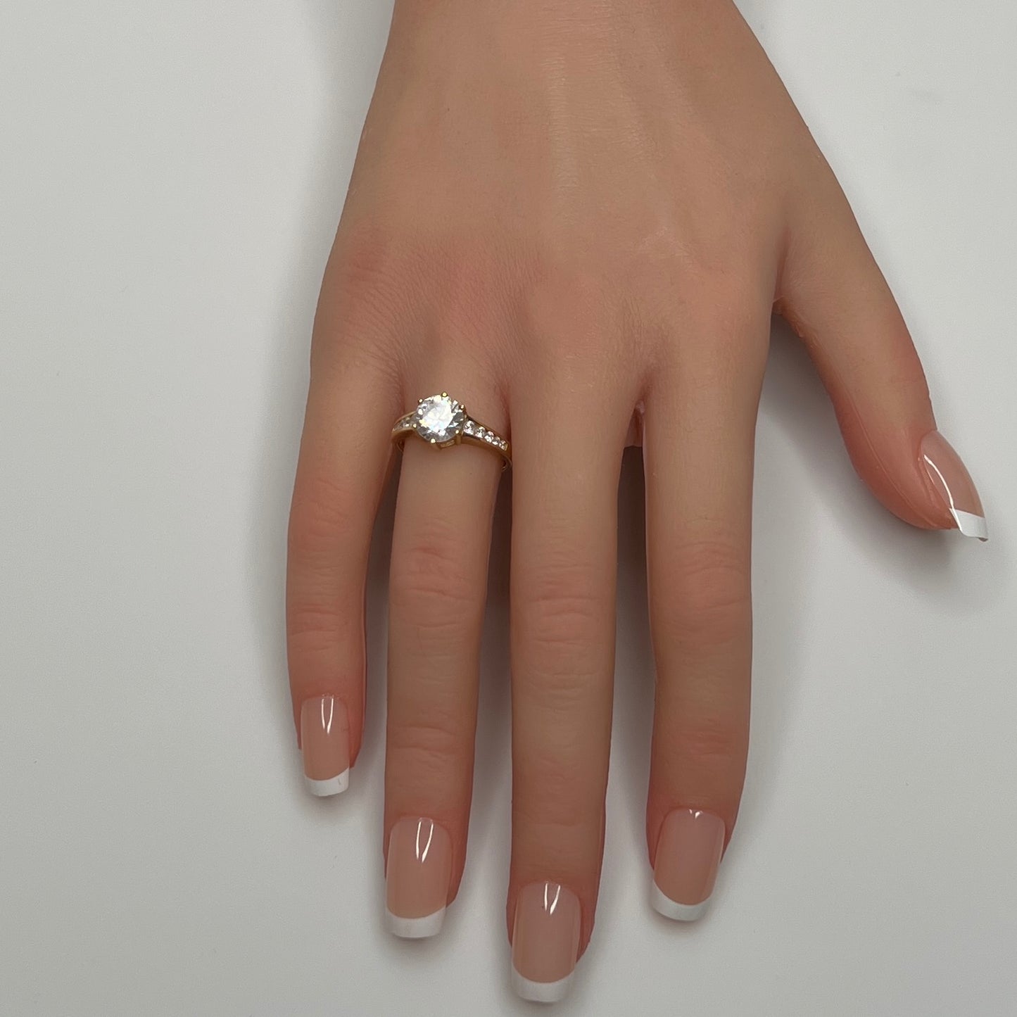 Vintage 10K gold CZ solitaire ring on hand with channel-set accents