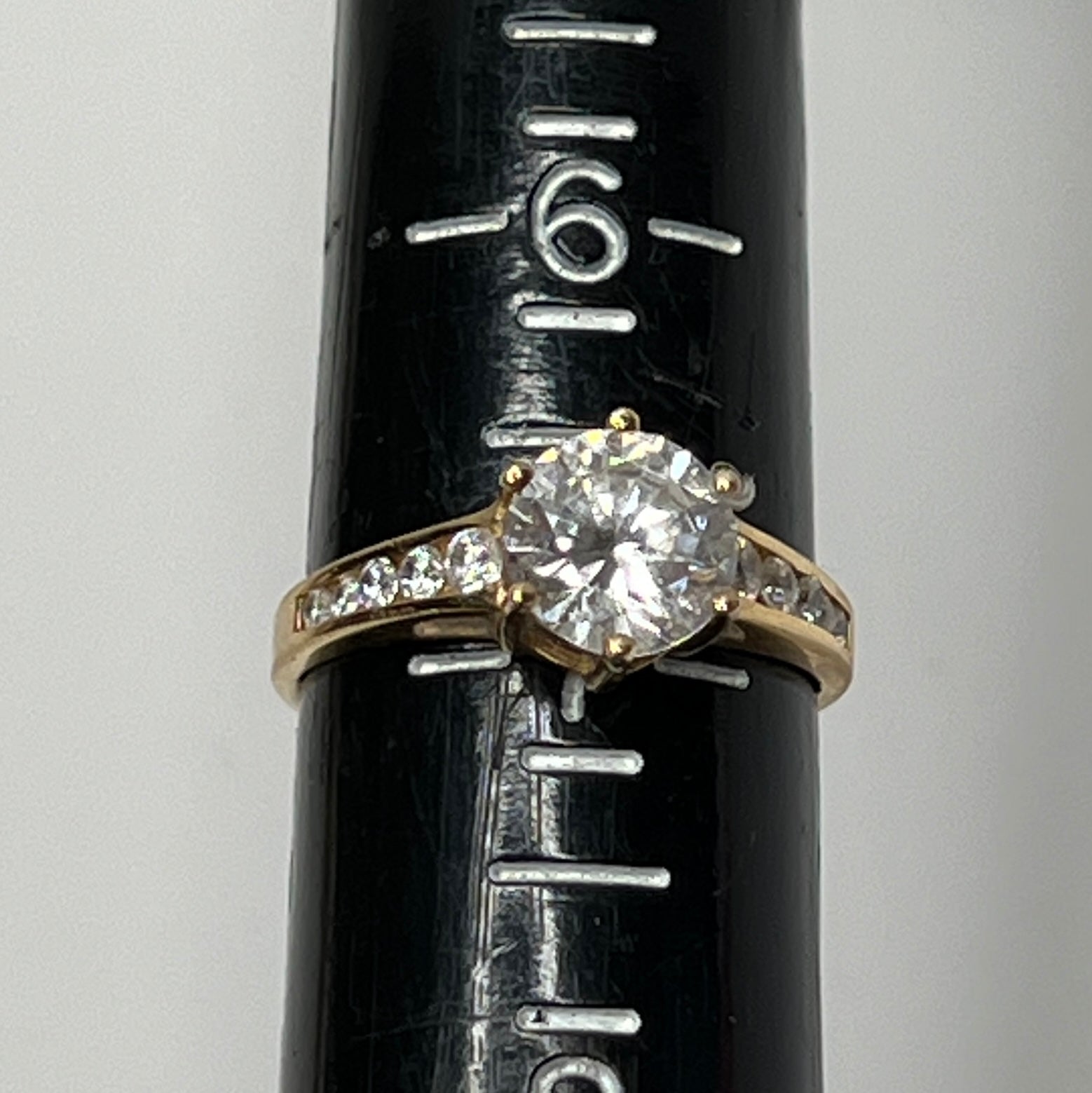 Vintage 10K gold CZ solitaire ring on hand with channel-set accents