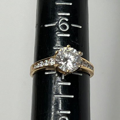 Vintage 10K gold CZ solitaire ring on hand with channel-set accents