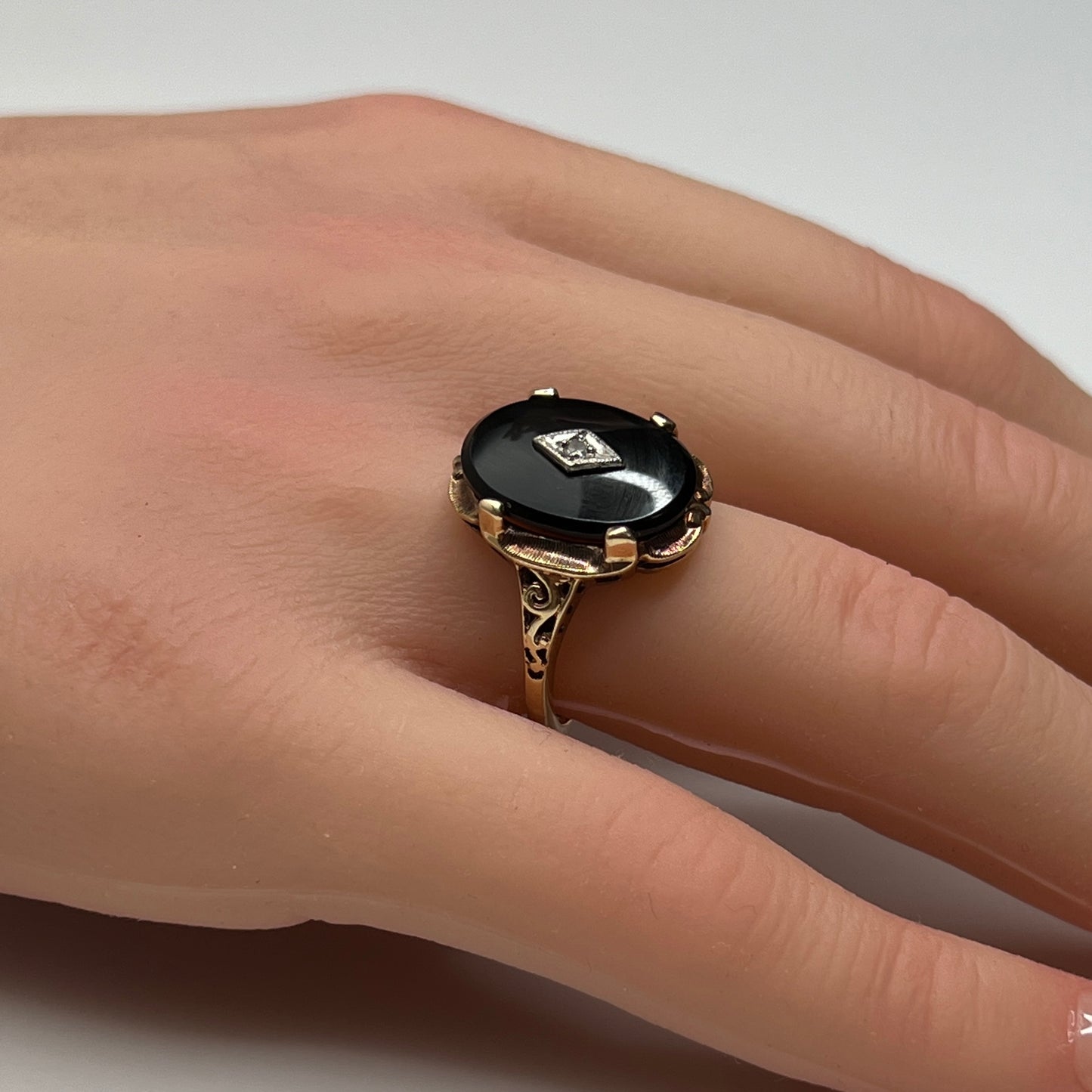 Vintage black onyx and diamond ring in 10K gold on hand, Art Deco style