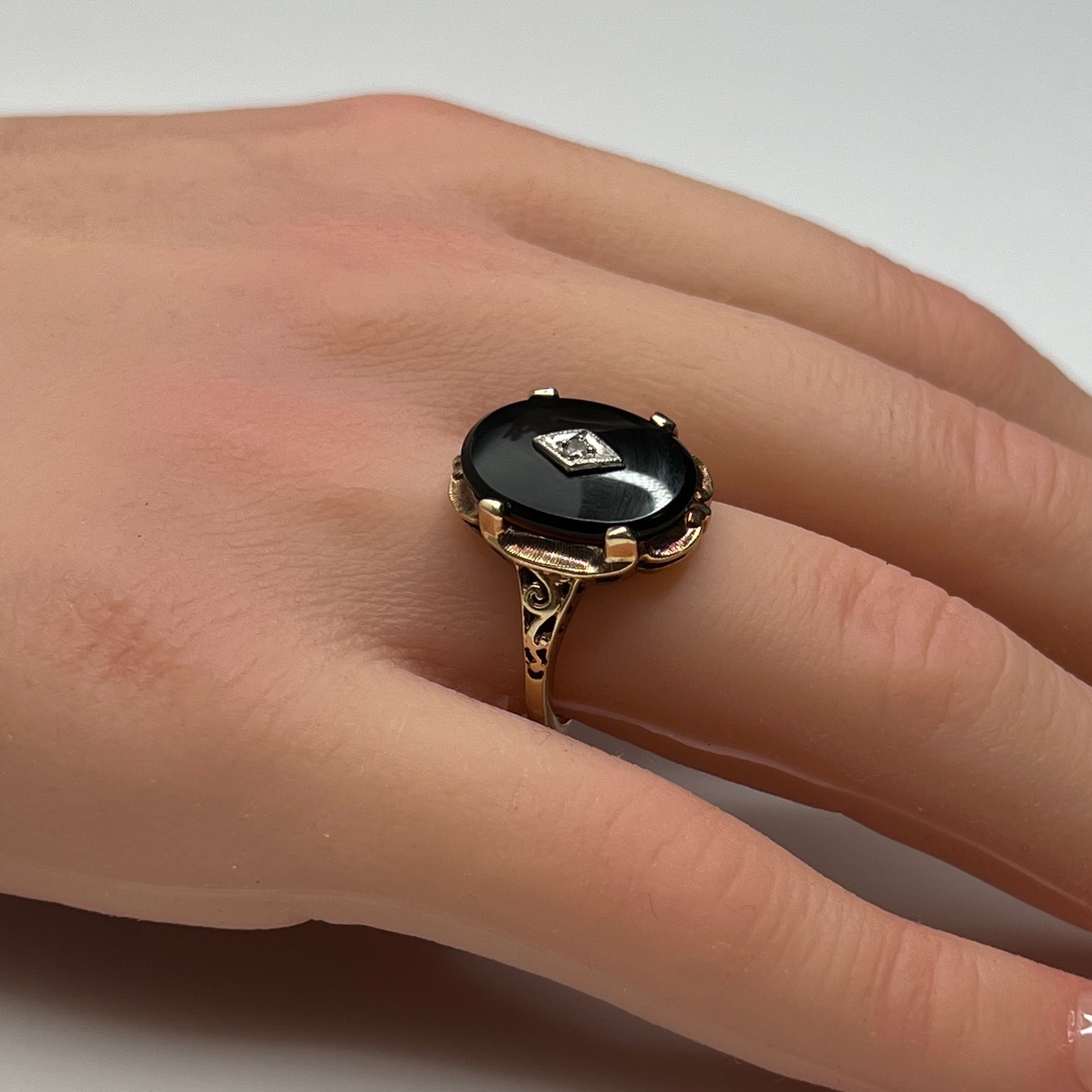 Vintage black onyx and diamond ring in 10K gold on hand, Art Deco style