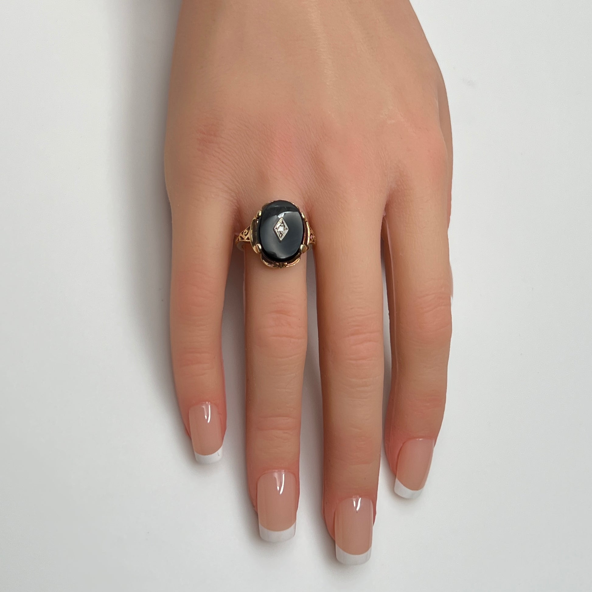 Vintage black onyx and diamond ring in 10K gold on hand, Art Deco style