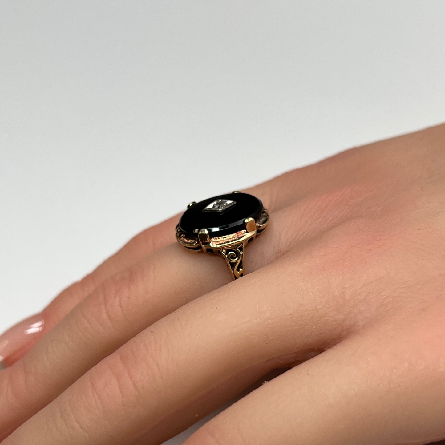 Vintage black onyx and diamond ring in 10K gold on hand, Art Deco style