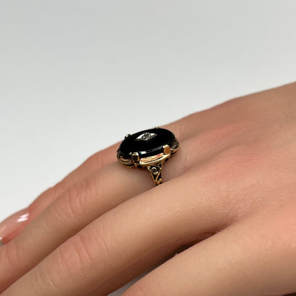 Vintage black onyx and diamond ring in 10K gold on hand, Art Deco style