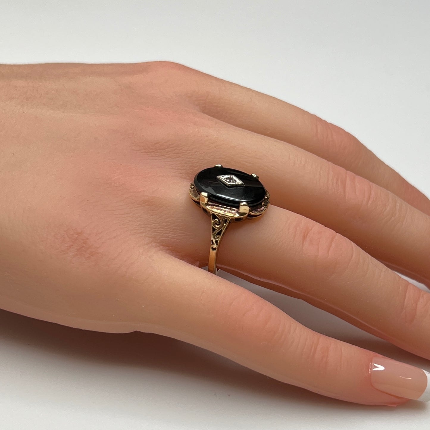 Vintage black onyx and diamond ring in 10K gold on hand, Art Deco style