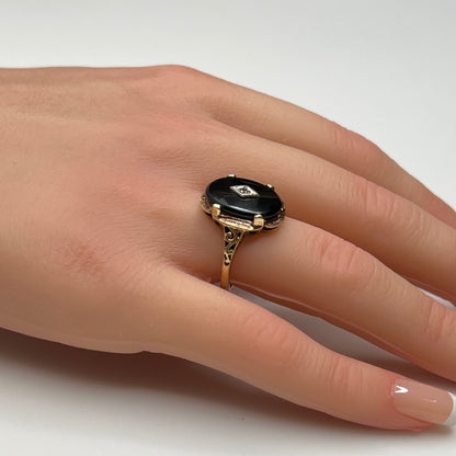 Vintage black onyx and diamond ring in 10K gold on hand, Art Deco style
