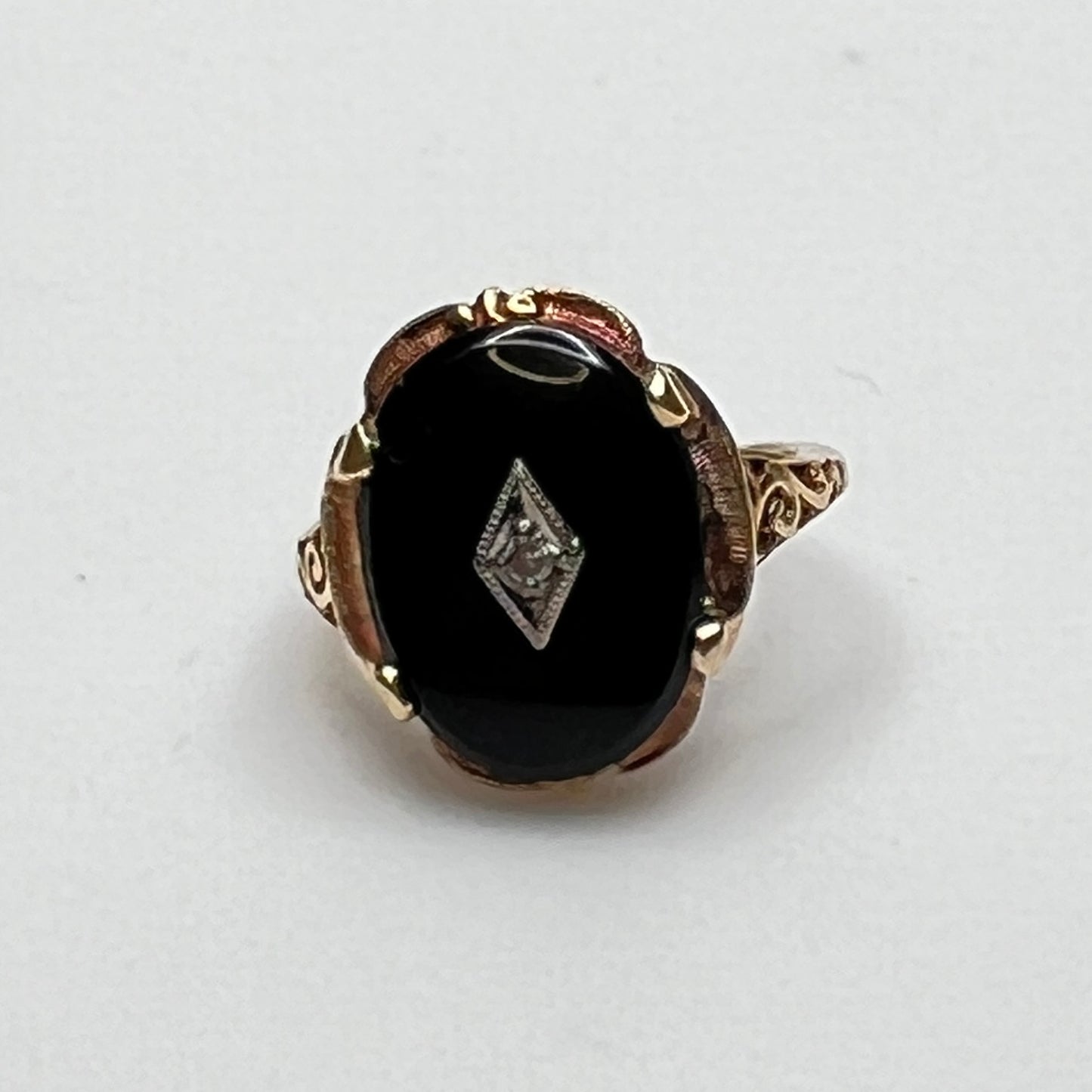 Close-up of prong-set black onyx cabochon with central diamond