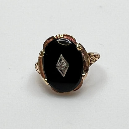 Close-up of prong-set black onyx cabochon with central diamond
