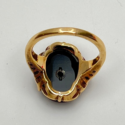Close-up of prong-set black onyx cabochon with central diamond